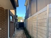 Light grey Colorbond fence with a lattice topper down the side