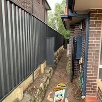 Monument Colorbond fence along a brick house