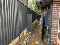 Monument Colorbond fence along a brick house