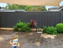 Monument Colorbond fence around a paved courtyard
