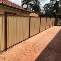 Paperbark Colorbond fence along a brick path