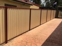 Paperbark Colorbond fence along a brick path