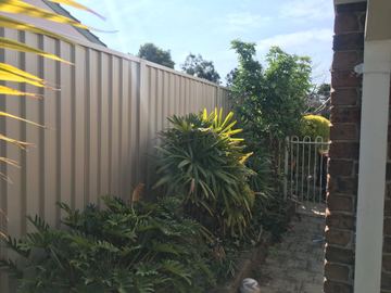 Shale grey Colorbond fence along a garden bed