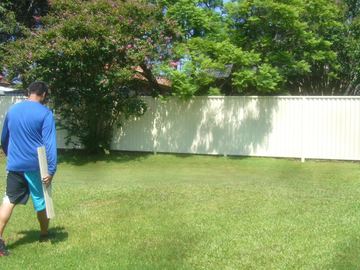 White Colorbond fence across a back lawn
