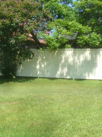 White Colorbond fence across a back lawn
