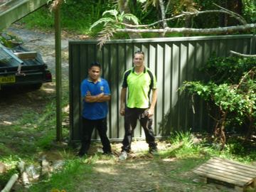 Woodland grey Colorbond fence with the installers beside it