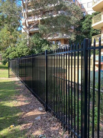 Spear-top security run with a matching black gate opening onto a driveway.