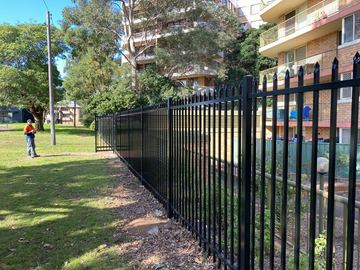 Spear-top security run with a matching black gate opening onto a driveway.