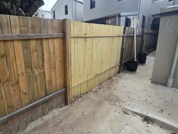 New treated pine palings beside paved areas.