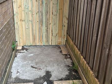 New treated pine palings beside paved areas.