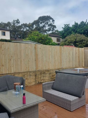 New treated pine palings beside paved areas.