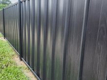 Close view of Black Ash woodgrain steel sheets showing the vertical rib and grain