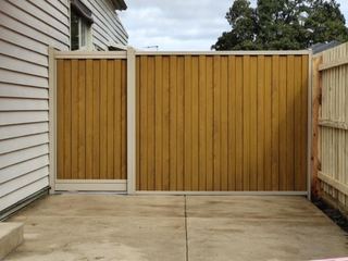 Light Oak woodgrain steel gate beside a matching fixed panel